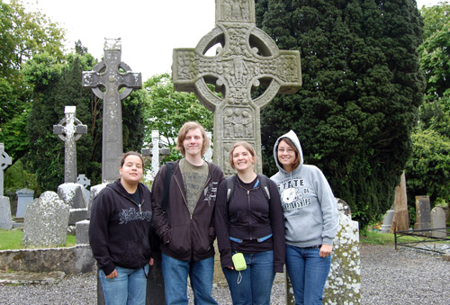 The crew in front of a beautiful cross